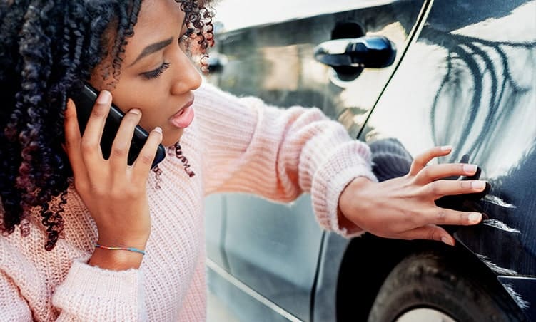 Woman checking car scratches