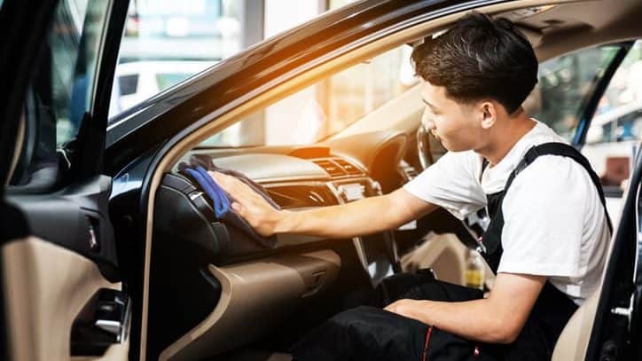 wiping down a car's dashboard 